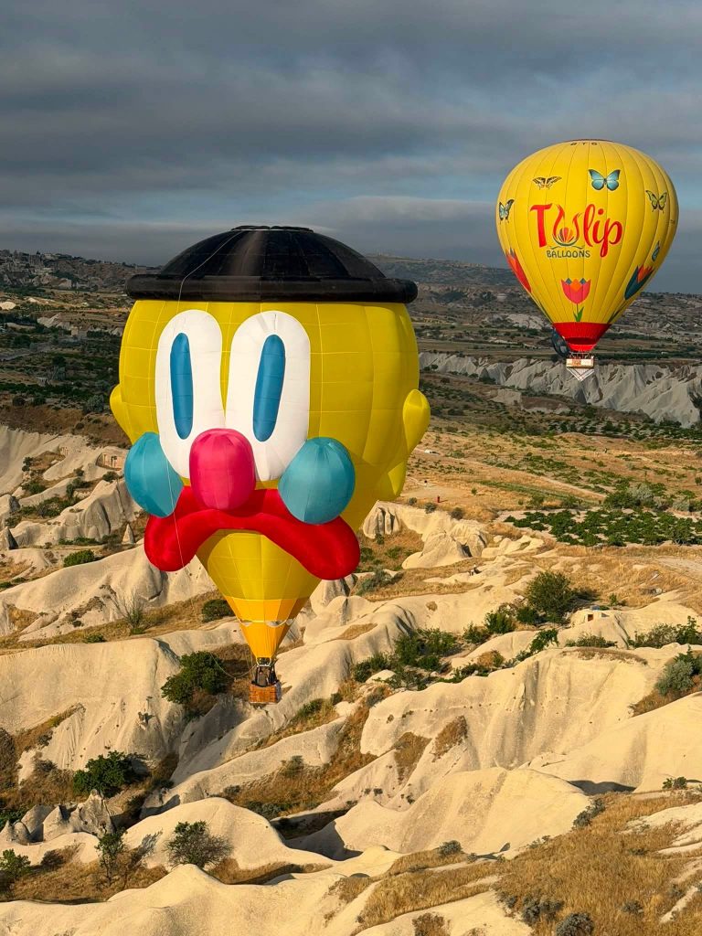 Slawn hot air balloon flying over festival in Cappadocia turkey hot air ballon turkey. hot air balloon art. custom character hot air balloon. custom shape. custom shape hot air balloon. hot air balloon festival turkey. hot air balloon art.